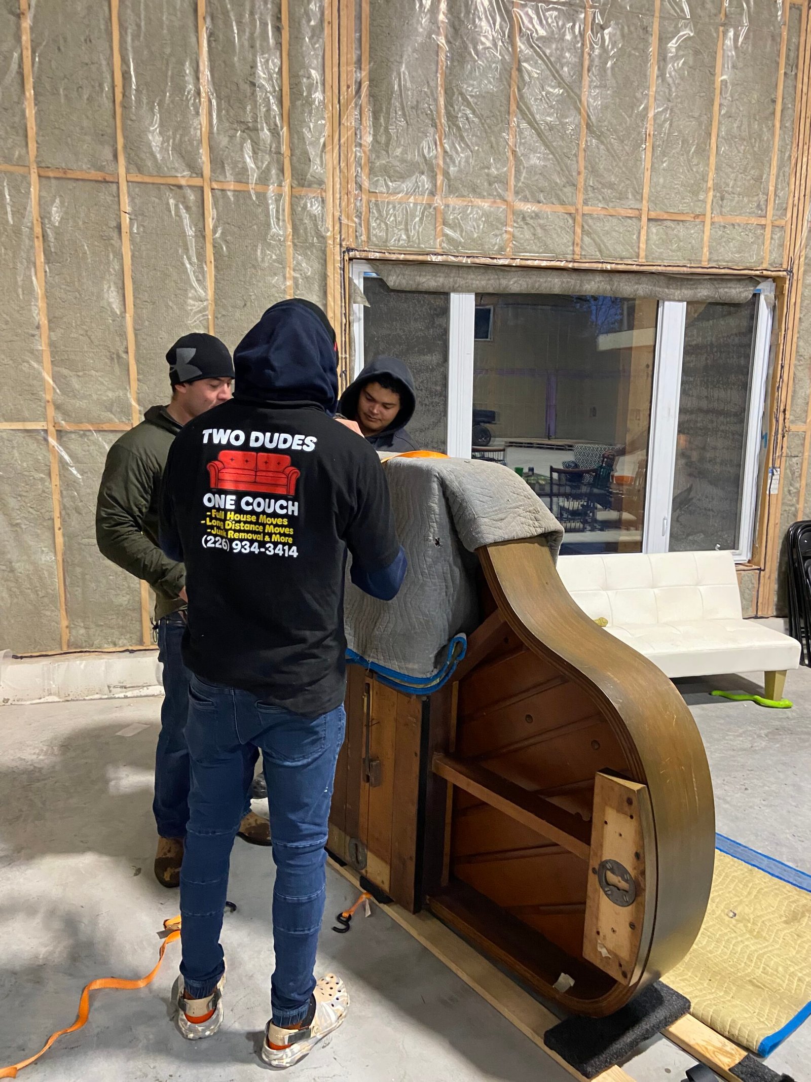 Grand piano being moved sideways on a piano board.